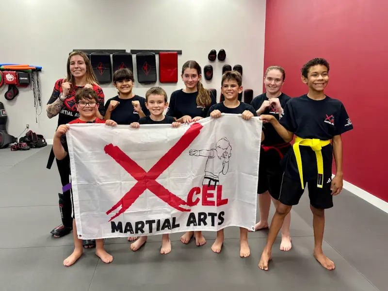 Xcel Martial Arts students holding banner at Boca Raton academy