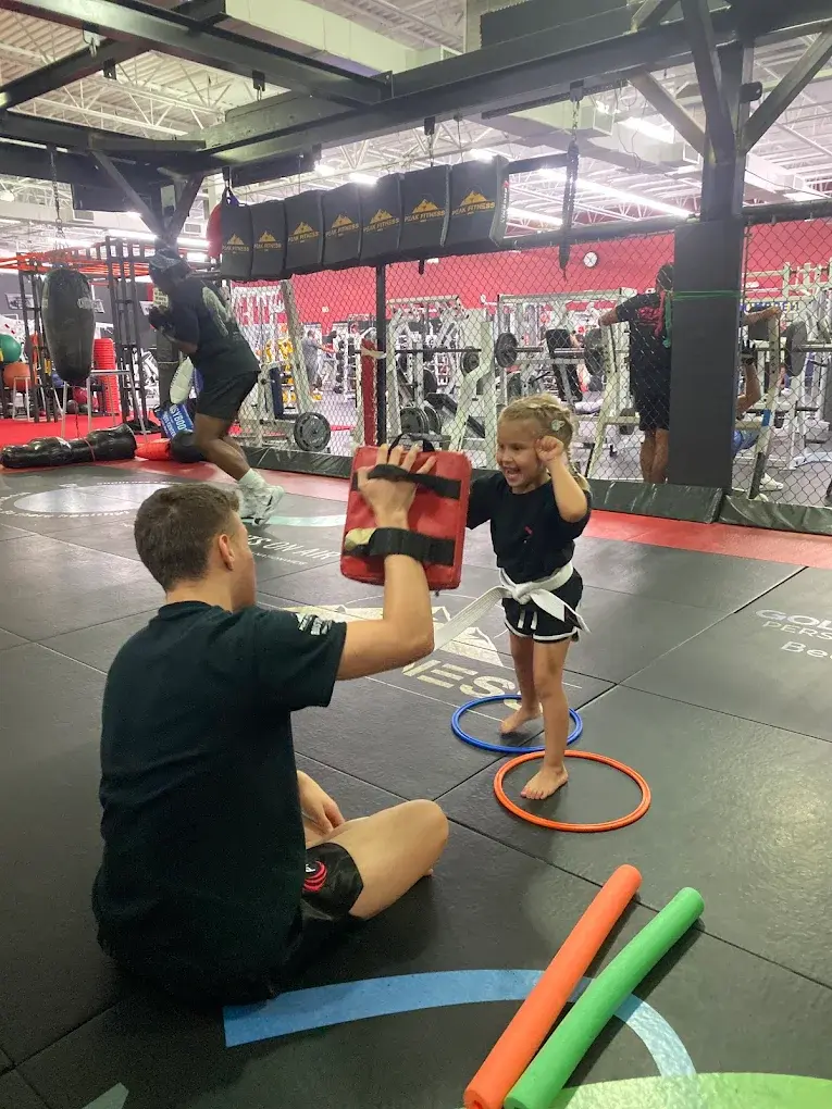 Young girl practicing kickboxing with pad work at Xcel Martial Arts Boca Raton